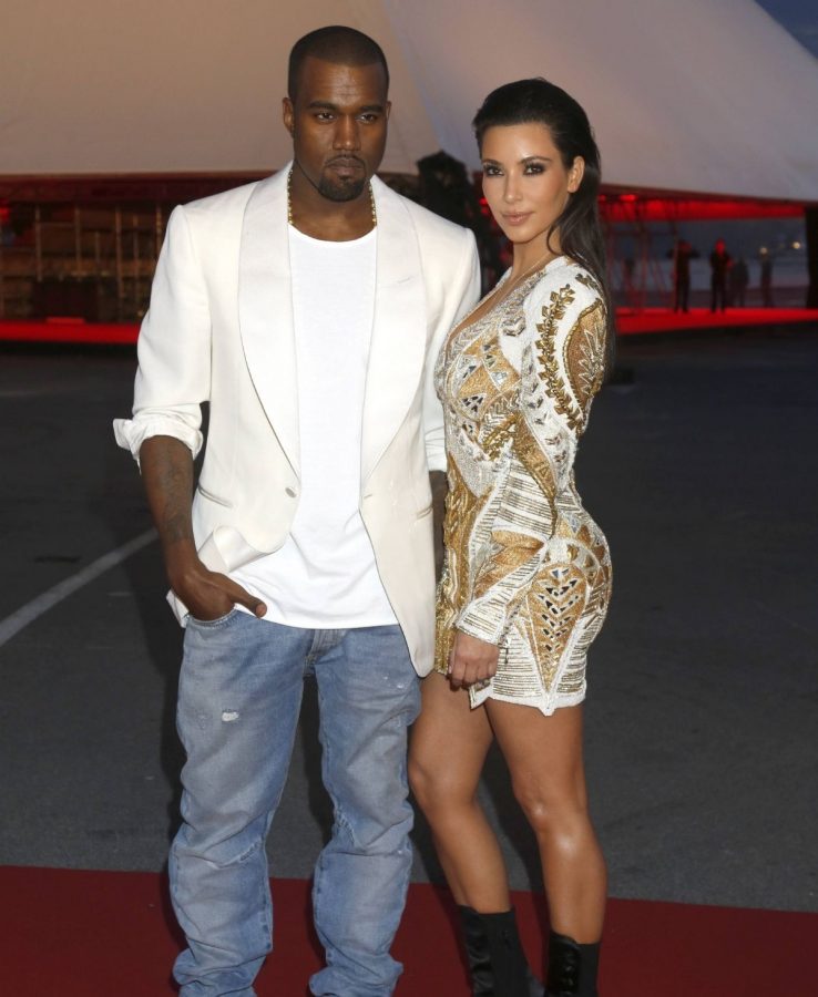 Kanye West in Jeans und weißem Hemd mit Kim Kardashian im Minikleid 2012