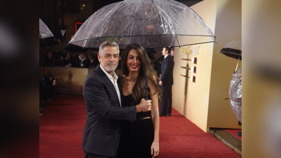 George und Amal Clooney mit Regenschirm in London. (hub/spot)