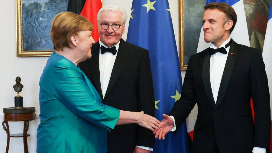 Nachdem sie Bundespräsident Frank-Walter Steinmeier begrüßt hatte, schüttelte Angela Merkel Emmanuel Macron herzlich die Hand. (ae/spot)