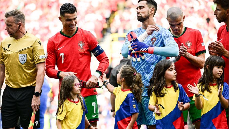 Fußball-EM 2024: Fußball-Superstar Cristiano Ronaldo wird von dem kleinen Einlaufmädchen am Arm berührt. (ili/spot)