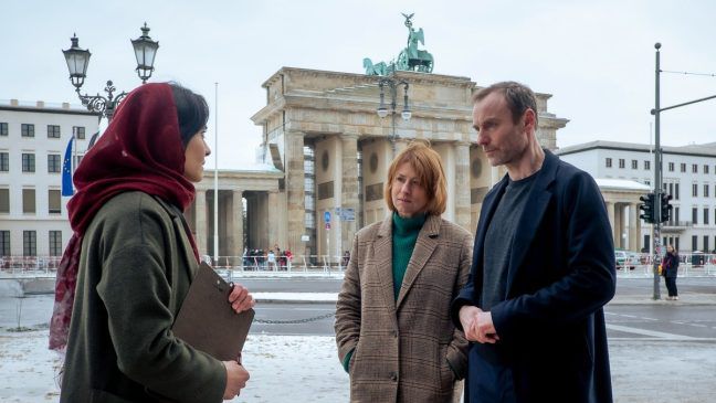 "Tatort: Vier Leben": Susanne Bonard (Corinna Harfouch, M.) und Robert Karow (Mark Waschke, r.) finden die Verdächtige Soraya Barakzay (Pegah Ferydoni, l.) bei einer Protestaktion vor dem Brandenburger Tor. (eyn/spot)